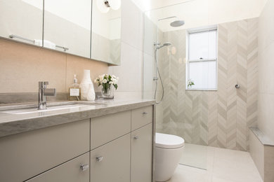 Design ideas for a mid-sized contemporary master wet room bathroom in Melbourne with grey cabinets, a one-piece toilet, beige tile, porcelain tile, beige walls, porcelain floors, an undermount sink, quartzite benchtops, grey floor, an open shower, beige benchtops, a shower seat, a single vanity, a built-in vanity and vaulted.