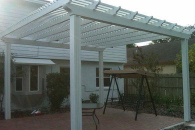 This is an example of a mid-sized traditional backyard patio in Orlando with brick pavers and a pergola.