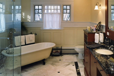Traditional bathroom in DC Metro with a claw-foot tub, a corner shower, multi-coloured tile and yellow walls.