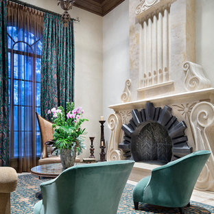 Modelo de salón cerrado, mediterráneo, grande, sin televisor, con chimenea tradicional, suelo beige, paredes beige, suelo de mármol y marco de chimenea de piedra