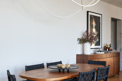 Imagen de comedor abierto con paredes blancas y suelo marrón