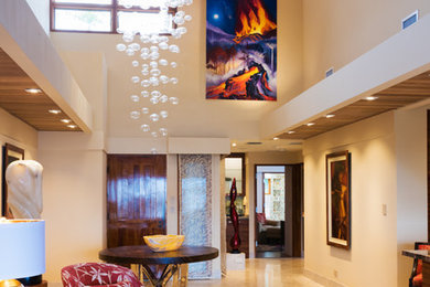 Inspiration for a transitional limestone floor entryway remodel in Hawaii with beige walls and a medium wood front door