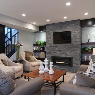 Classic fully buried basement in Calgary with a ribbon fireplace and a stone fireplace surround.