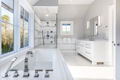 Inspiration for a large master gray tile and ceramic tile ceramic tile, white floor, single-sink, vaulted ceiling and wainscoting bathroom remodel in New York with flat-panel cabinets, white cabinets, a one-piece toilet, gray walls, a drop-in sink, marble countertops, a hinged shower door, white countertops and a freestanding vanity