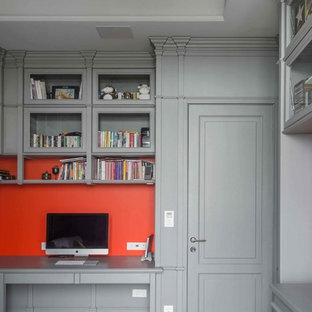 Inspiration for a mid-sized transitional study room in Moscow with grey walls, light hardwood floors, a built-in desk, beige floor, a standard fireplace and a wood fireplace surround.