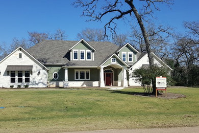 Example of a mid-sized arts and crafts gray two-story mixed siding house exterior design in Austin with a hip roof and a shingle roof