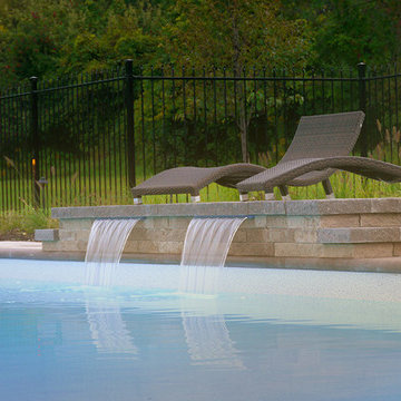 Pool with a firepit by Exact Landscapes