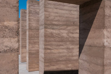 Example of a minimalist brown one-story adobe house exterior design in Other