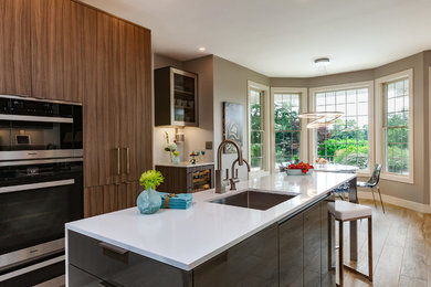 Photo of a mid-sized contemporary l-shaped eat-in kitchen in Other with an undermount sink, flat-panel cabinets, grey cabinets, quartz benchtops, white splashback, glass sheet splashback, stainless steel appliances, porcelain floors, with island and grey floor.