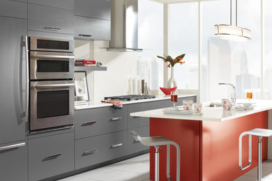 Inspiration for a mid-sized contemporary single-wall gray floor eat-in kitchen remodel in New York with an undermount sink, flat-panel cabinets, gray cabinets, white backsplash, stainless steel appliances, an island and white countertops