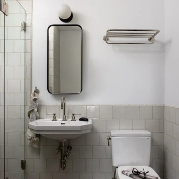 Renovated Bathroom with Warm Neutral Tile and Black-Framed Mirror