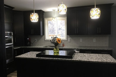 Photo of a kitchen in New York with shaker cabinets, dark wood cabinets, granite worktops and an island.