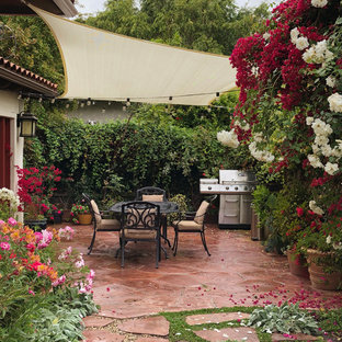 Großer Stilmix Garten im Frühling, hinter dem Haus mit direkter Sonneneinstrahlung und Natursteinplatten