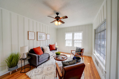 Example of a mid-sized cottage formal and open concept light wood floor, brown floor and wall paneling living room design in Salt Lake City with white walls and a tv stand
