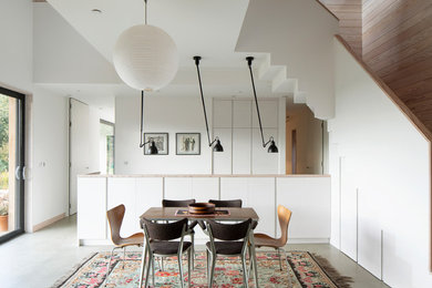 Inspiration for a contemporary open plan dining room in Sussex with concrete flooring and grey floors.