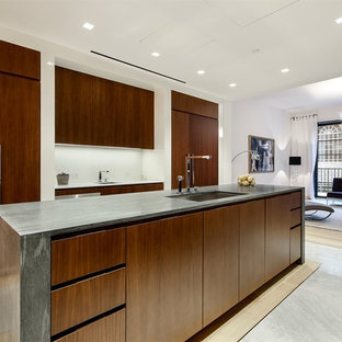 На фото: отдельная, параллельная кухня среднего размера в стиле модернизм с врезной раковиной, плоскими фасадами, темными деревянными фасадами, белым фартуком, техникой под мебельный фасад и островом с