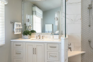 Inspiration for a large transitional master porcelain tile and gray floor corner shower remodel with furniture-like cabinets, beige cabinets, a two-piece toilet, gray walls, an undermount sink, quartz countertops, a hinged shower door and beige countertops