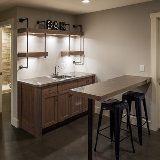 ミネアポリスの中サイズのカントリー風おしゃれなウェットバー (ドロップインシンク、シェーカースタイル扉のキャビネット、ヴィンテージ仕上げキャビネット、ステンレスカウンター、コンクリートの床、グレーの床) の写真