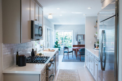 Open concept kitchen - small transitional galley porcelain tile and beige floor open concept kitchen idea in Orange County with a double-bowl sink, shaker cabinets, beige cabinets, quartz countertops, white backsplash, subway tile backsplash, stainless steel appliances, no island and white countertops
