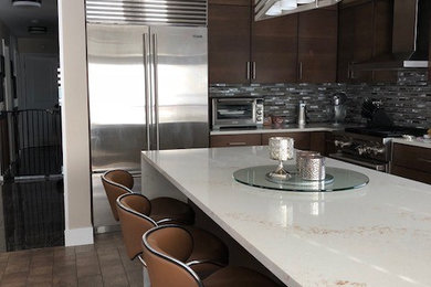 Example of a mid-sized minimalist l-shaped vinyl floor and brown floor enclosed kitchen design in New York with an undermount sink, flat-panel cabinets, medium tone wood cabinets, quartz countertops, gray backsplash, matchstick tile backsplash, stainless steel appliances, an island and white countertops