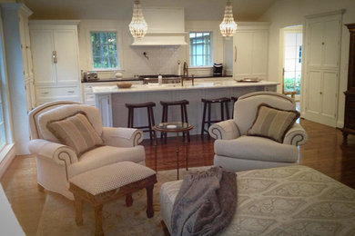 Small transitional u-shaped dark wood floor kitchen pantry photo in New York with a farmhouse sink, flat-panel cabinets, white cabinets, granite countertops, white backsplash, ceramic backsplash, stainless steel appliances and an island