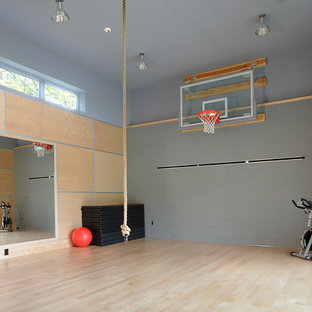 Large modern indoor sports court in Seattle with grey walls and light hardwood flooring.