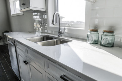 Foto de cocina minimalista con fregadero de doble seno, puertas de armario blancas, salpicadero blanco y encimeras blancas