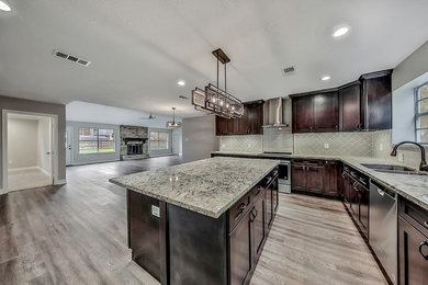 Kitchen - contemporary brown floor kitchen idea in Houston with an undermount sink, black cabinets, granite countertops, beige backsplash, mosaic tile backsplash and stainless steel appliances