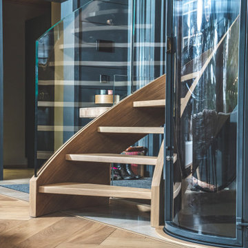 Bogentreppen aus Holz mit Glasgeländer, Fahrstuhl und Glasbrücke - Siller Treppe