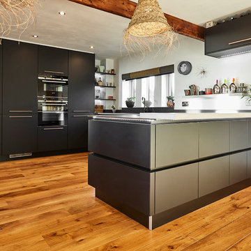 Handle-less Black kitchen with Copper accents & bespoke Concrete breakfast bar