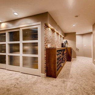 This is an example of an expansive traditional fully buried basement in Denver with red walls, carpet and beige floors.