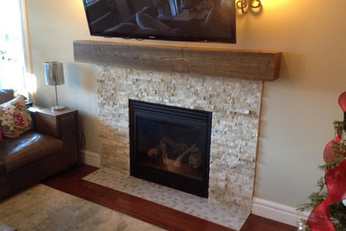 Example of a multicolored floor family room design in Edmonton with gray walls, no fireplace, a stone fireplace and a wall-mounted tv