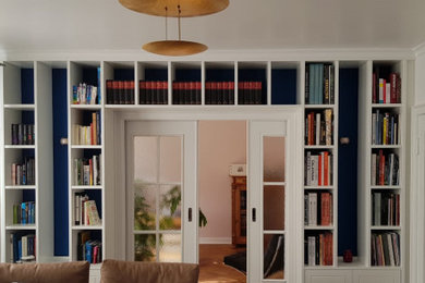 Foto de biblioteca en casa tradicional de tamaño medio con paredes azules y suelo de madera en tonos medios