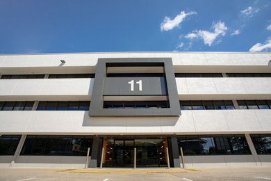 Photo of an expansive contemporary concrete white exterior in Brisbane with four or more storeys, a flat roof, a metal roof and a grey roof.