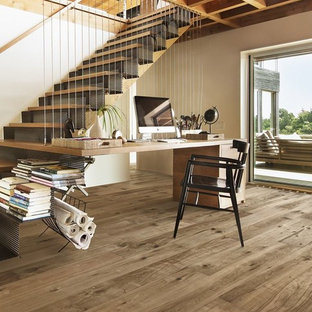 Inspiration for a large modern home office and library in Denver with black walls, medium hardwood flooring and a built-in desk.