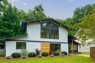 Inspiration for a mid-sized 1960s gray two-story mixed siding and board and batten exterior home remodel in Atlanta with a shingle roof and a black roof