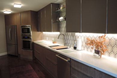 Enclosed kitchen - modern galley medium tone wood floor and brown floor enclosed kitchen idea in San Francisco with flat-panel cabinets, medium tone wood cabinets, quartzite countertops, multicolored backsplash, mosaic tile backsplash, stainless steel appliances and white countertops