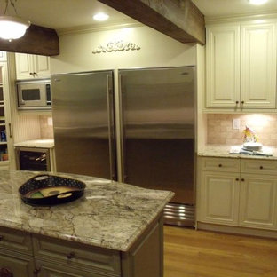 Idéer för att renovera ett mellanstort vintage kök, med en rustik diskho, luckor med upphöjd panel, vita skåp, granitbänkskiva, beige stänkskydd, stänkskydd i kalk, rostfria vitvaror, mellanmörkt trägolv, en köksö och flerfärgat golv