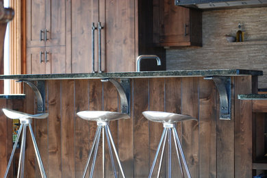 Kitchen - mid-sized rustic kitchen idea in Denver with shaker cabinets, dark wood cabinets, granite countertops, beige backsplash and stainless steel appliances