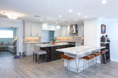 Photo of a mid-sized contemporary kitchen in Miami with shaker cabinets, white cabinets, multi-coloured splashback, glass tile splashback, stainless steel appliances and with island.