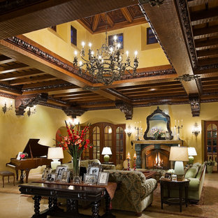 Photo of an expansive mediterranean formal living room in Los Angeles with yellow walls, travertine flooring and a standard fireplace.