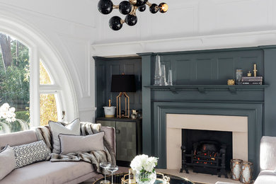 Traditional formal and grey and teal living room in Dorset with blue walls, a standard fireplace and no tv.