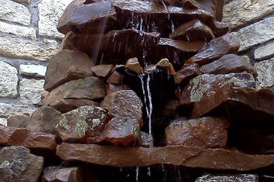 Photo of a small rustic full sun backyard water fountain landscape in Austin.