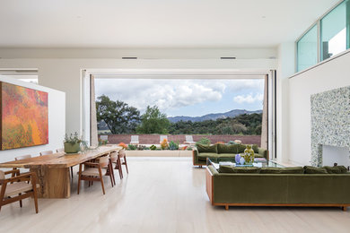 Huge trendy open concept light wood floor and beige floor living room photo in Los Angeles with white walls, a standard fireplace and a tile fireplace