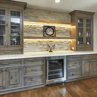 サンフランシスコの中サイズのラスティックスタイルのおしゃれなホームバー (インセット扉のキャビネット、グレーのキャビネット、珪岩カウンター、ベージュキッチンパネル、石タイルのキッチンパネル、無垢フローリング、茶色い床、白いキッチンカウンター) の写真