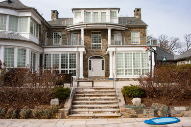 Example of a large classic brown three-story stone exterior home design in DC Metro with a shingle roof