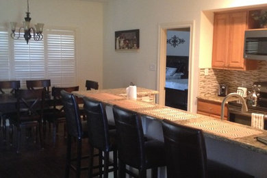 Minimalist dark wood floor eat-in kitchen photo in Austin with a drop-in sink, light wood cabinets, granite countertops, beige backsplash, ceramic backsplash, stainless steel appliances and an island
