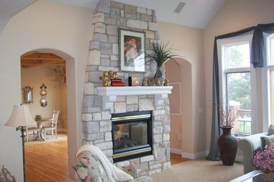 Photo of a traditional living room in Other with beige walls, medium hardwood floors, a corner fireplace, a stone fireplace surround and a freestanding tv.