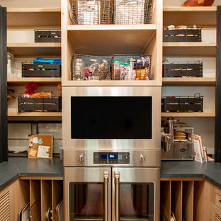 Kleine Landhaus Küche in U-Form mit Vorratsschrank, Lamellenschränken, hellen Holzschränken, Quarzwerkstein-Arbeitsplatte, Küchengeräten aus Edelstahl, hellem Holzboden, braunem Boden und schwarzer Arbeitsplatte in Sonstige