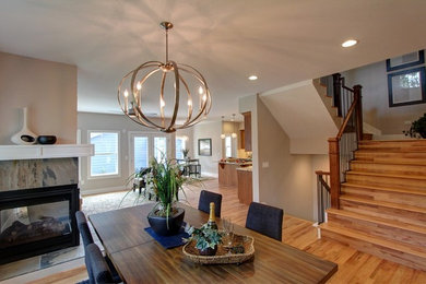 Arts and crafts dining room photo in Denver with beige walls, a two-sided fireplace and a stone fireplace